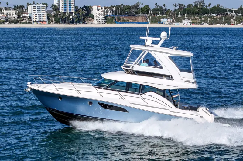 Slide: The Image of 2018 Tiara Yachts 44 Flybridge cruising near historic ship. - 49