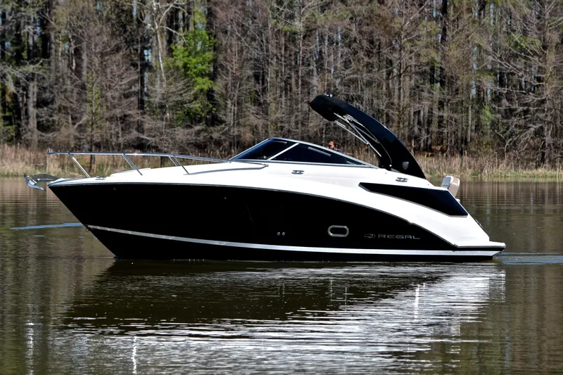 Slide: The Image of 2016 Regal 26 Express boat on calm lake with forest backdrop. - 10