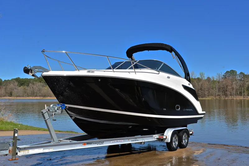 Slide: The Image of 2016 Regal 26 Express boat on trailer by a lake under clear blue sky. - 12