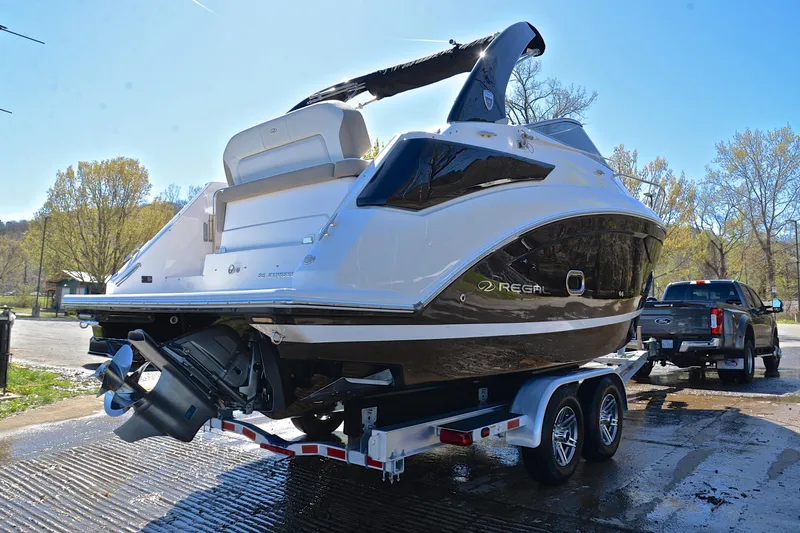 Slide: The Image of 2016 Regal 26 Express boat on trailer, parked outdoors in sunny setting. - 16