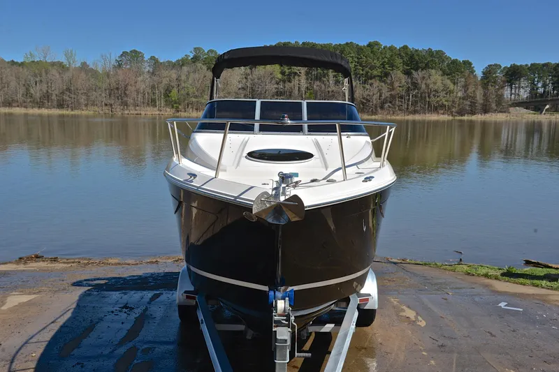 Slide: The Image of 2016 Regal 26 Express boat on trailer by a serene lake. - 19