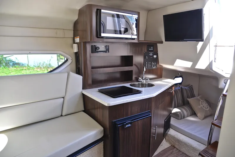 Slide: The Image of Interior of 2016 Regal 26 Express boat with kitchenette and seating area. - 30