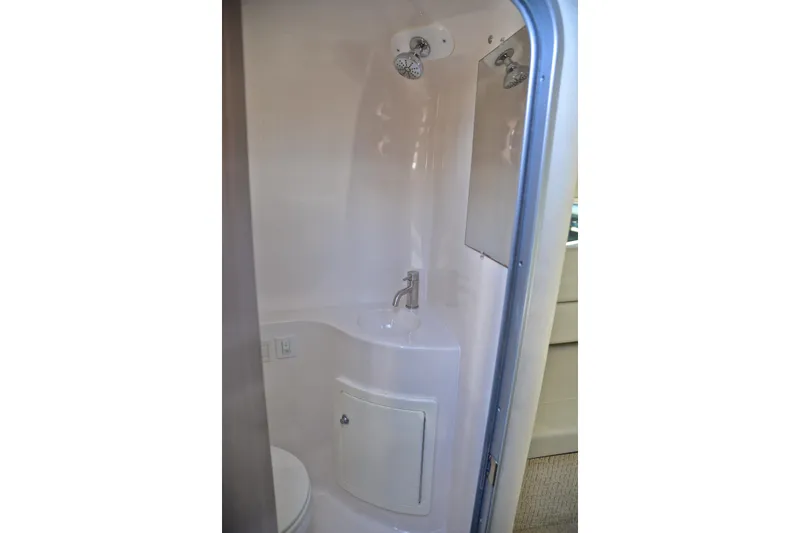 Slide: The Image of Compact bathroom in a 2016 Regal 26 Express boat, featuring a shower and sink. - 43