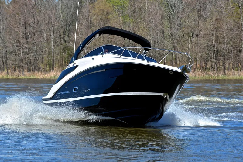 Slide: The Image of 2016 Regal 26 Express boat cruising on a lake with forested background. - 6