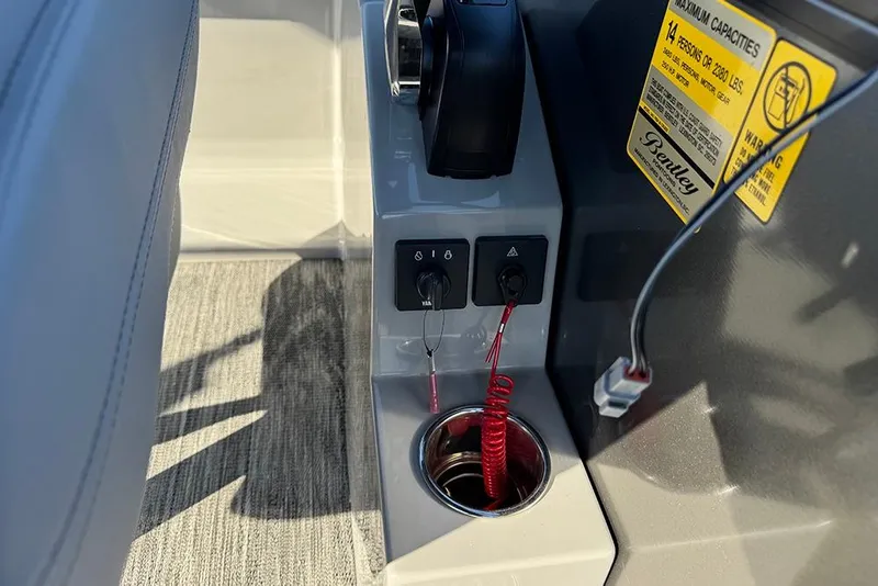 Slide: The Image of Control panel of 2026 Bentley Pontoons 243 Fish-N-Cruise with safety features and capacity label. - 35
