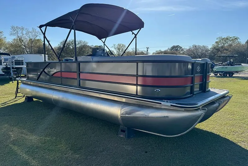 Slide: The Image of 2026 Bentley Pontoons 243 Fish-N-Cruise pontoon boat on grass, side view. - 8