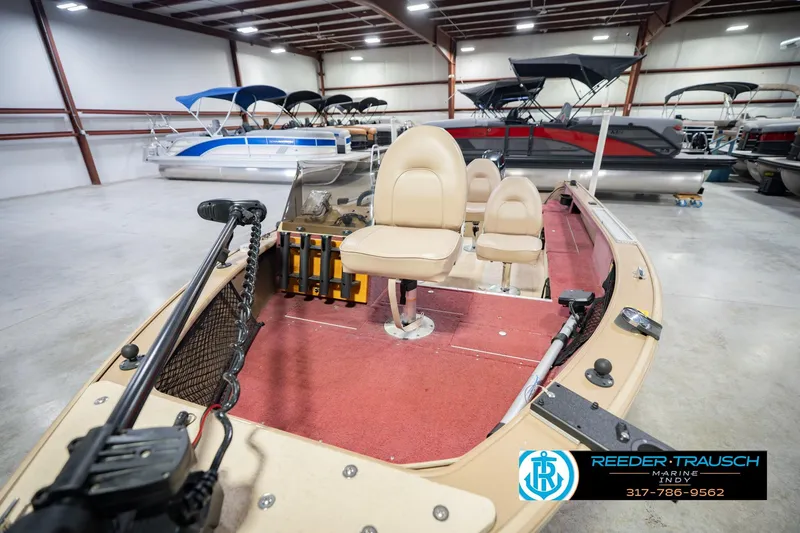 Slide: The Image of 1997 Lund 1650 Angler SS boat with beige seats in a showroom. - 11