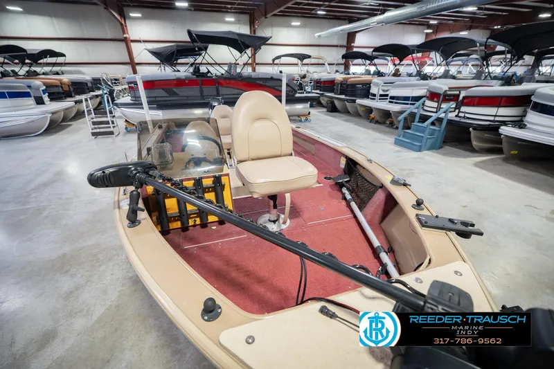 Slide: The Image of 1997 Lund 1650 Angler SS boat in showroom, featuring red interior and steering console. - 12