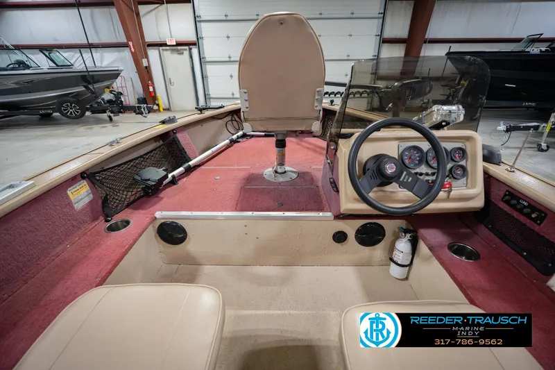 Slide: The Image of Interior view of a 1997 Lund 1650 Angler SS boat in a showroom. - 16