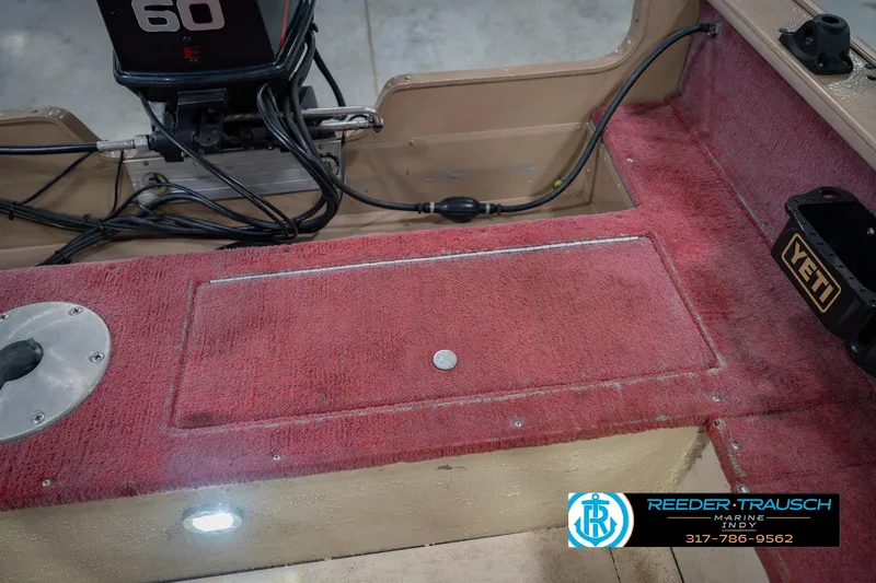 Slide: The Image of 1997 Lund 1650 Angler SS boat interior with red carpet and motor details. - 21