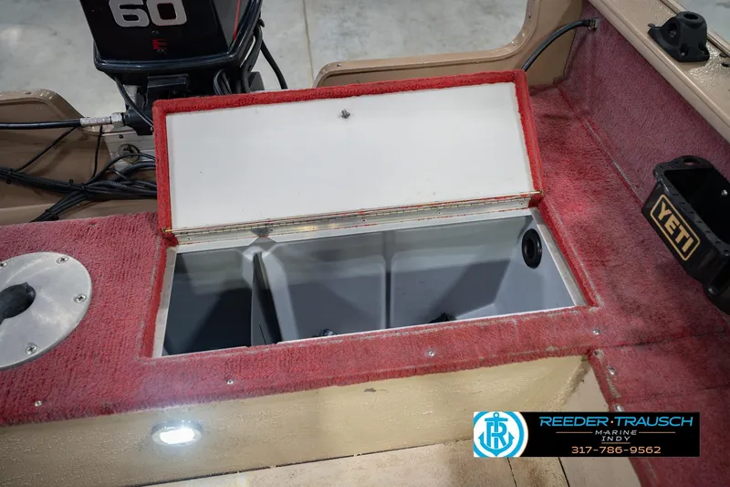 Slide: The Image of Open storage compartment on a 1997 Lund 1650 Angler SS boat with red interior. - 22