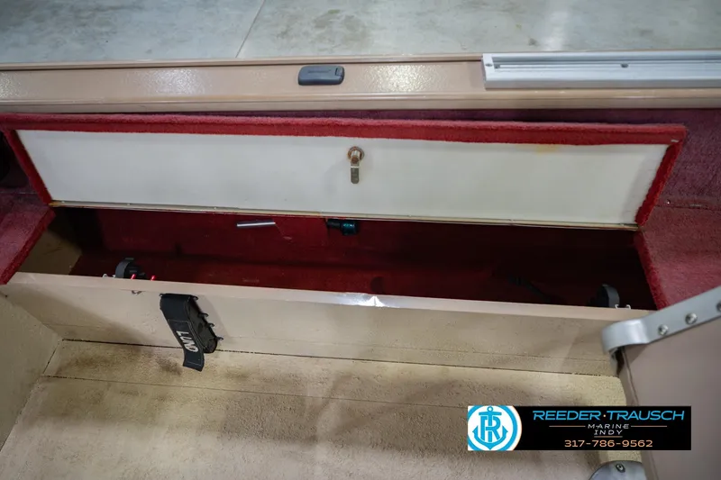 Slide: The Image of 1997 Lund 1650 Angler SS boat storage compartment with red interior and lockable door. - 24