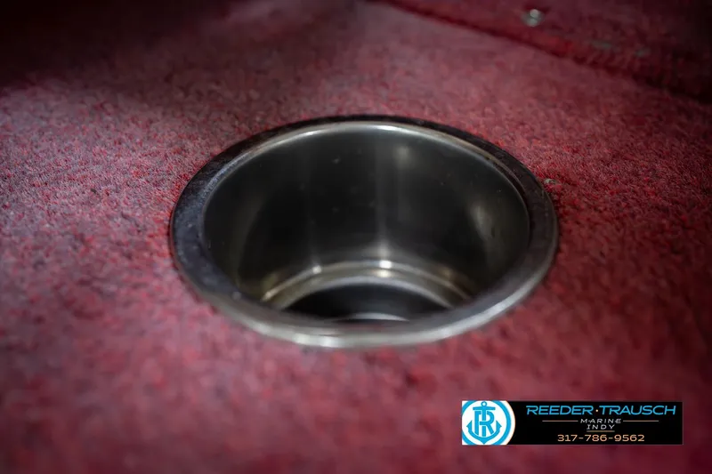 Slide: The Image of Red carpeted interior of a 1997 Lund 1650 Angler SS boat with a metal cup holder. - 40