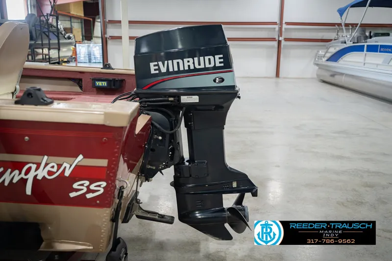 Slide: The Image of 1997 Lund 1650 Angler SS boat with Evinrude outboard motor in a showroom. - 42