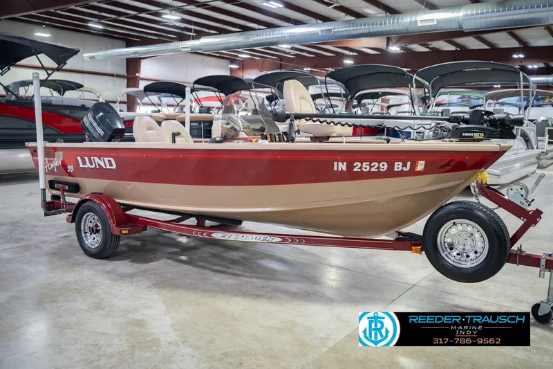Slide: The Image of 1997 Lund 1650 Angler SS boat on trailer in showroom, featuring Evinrude motor. - 5