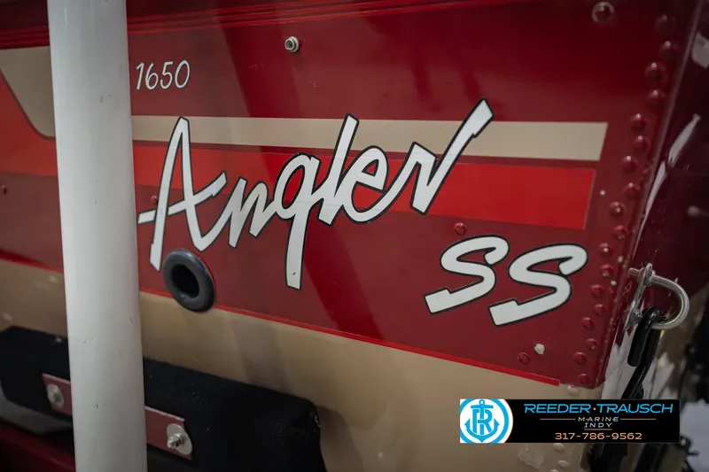 Slide: The Image of 1997 Lund 1650 Angler SS boat with red and beige detailing. - 51
