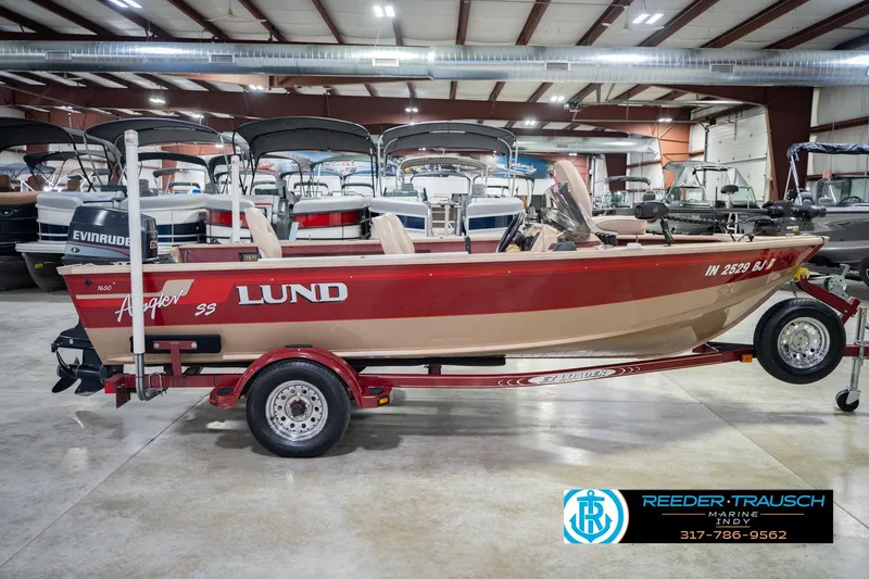 Slide: The Image of 1997 Lund 1650 Angler SS boat in showroom, red and beige, on trailer. - 6