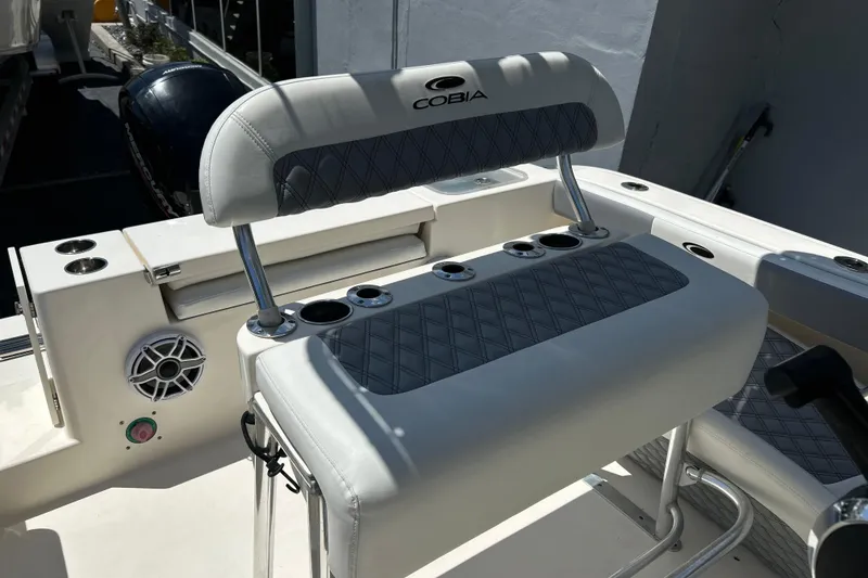 Slide: The Image of 2019 Cobia 220 Center Console boat interior with cushioned seating and cup holders. - 10
