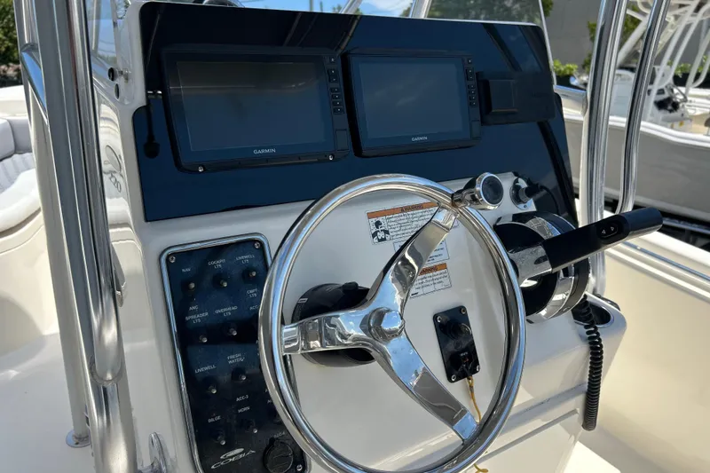 Slide: The Image of 2019 Cobia 220 Center Console boat dashboard with Garmin displays and steering wheel. - 15