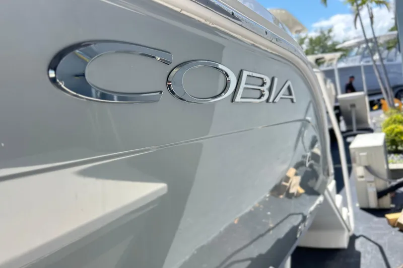 Slide: The Image of 2019 Cobia 220 Center Console boat with logo in focus, outdoor setting. - 7