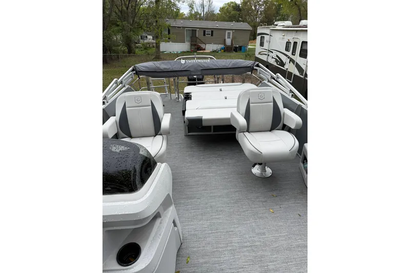 Slide: The Image of 2025 Godfrey Sweetwater 2286 pontoon boat interior with cushioned seating and helm. - 11
