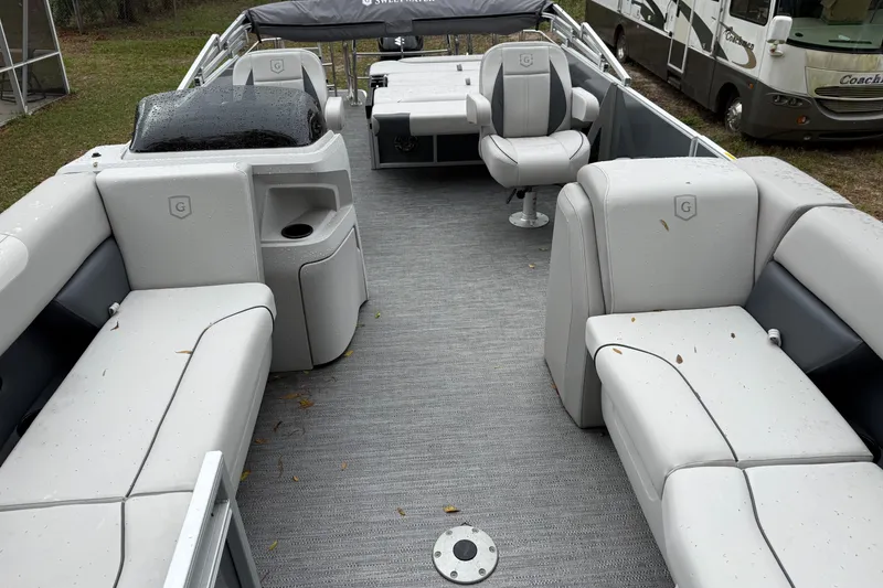 Slide: The Image of 2025 Godfrey Sweetwater 2286 pontoon boat interior with gray seating and helm. - 12