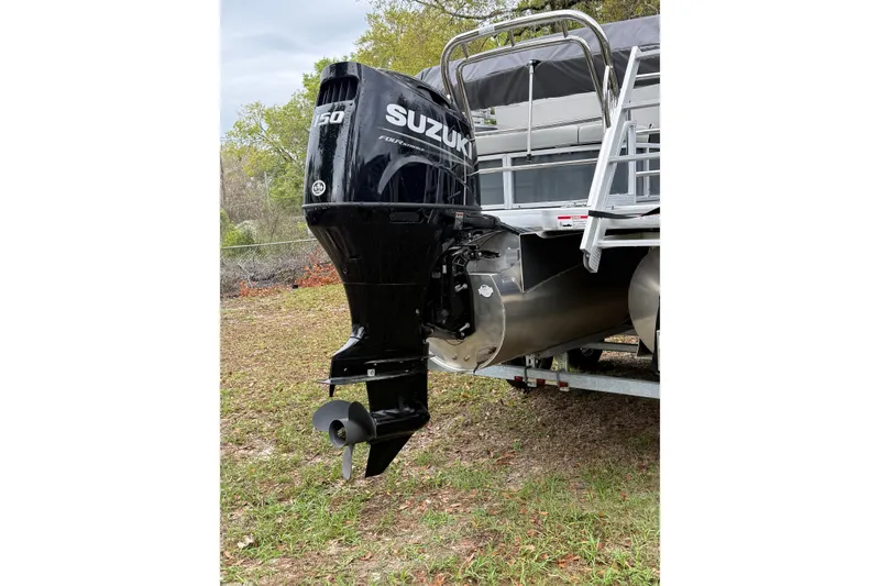 Slide: The Image of 2025 Godfrey Sweetwater 2286 with Suzuki 150 outboard motor on grassy terrain. - 4