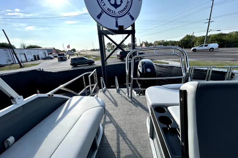 Slide: The Image of 2025 Godfrey Sweetwater 2286 SFL pontoon boat with canopy, parked in a marina. - 42