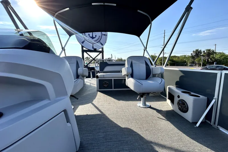 Slide: The Image of 2025 Godfrey Sweetwater 2286 SFL pontoon boat with canopy, parked in a marina. - 43