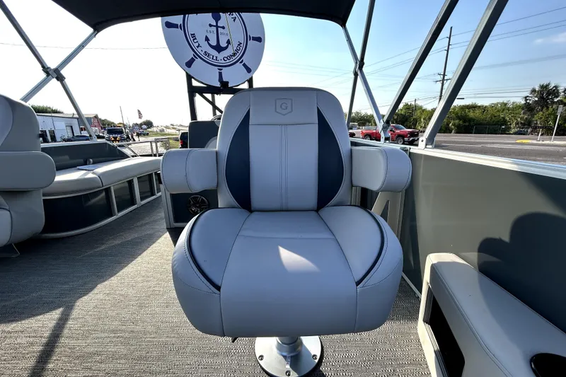 Slide: The Image of 2025 Godfrey Sweetwater 2286 SFL pontoon boat with canopy, parked in a marina. - 44