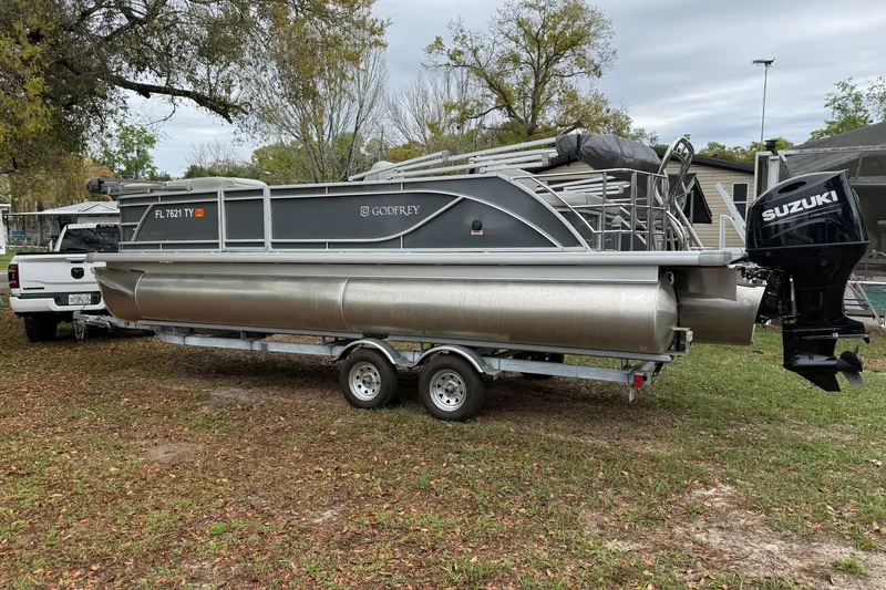 Slide: The Image of 2025 Godfrey Sweetwater 2286 pontoon boat on trailer with Suzuki outboard motor. - 5