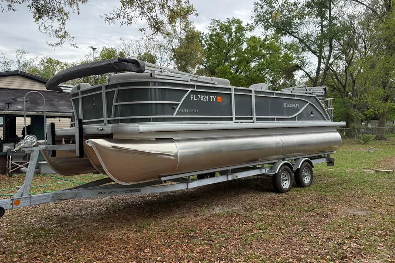 Slide: The Image of 2025 Godfrey Sweetwater 2286 pontoon boat on trailer, parked outdoors. - 6