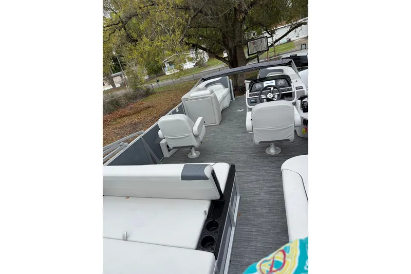 Slide: The Image of 2025 Godfrey Sweetwater 2286 pontoon boat interior with white seating and steering console. - 9