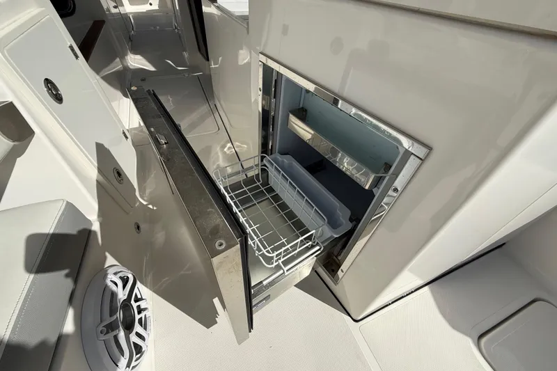 Slide: The Image of Open storage compartment on 2022 Pursuit DC 326 Dual Console boat interior. - 11