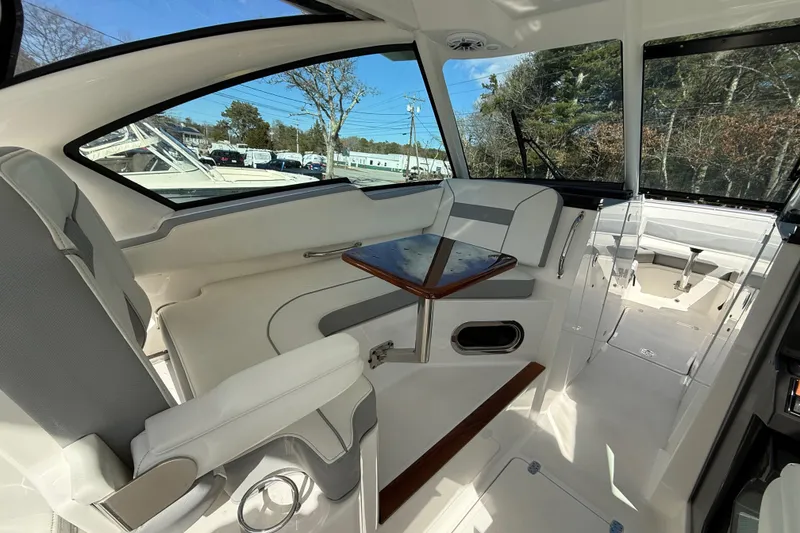 Slide: The Image of 2022 Pursuit DC 326 Dual Console interior with seating and table, showcasing modern design. - 12