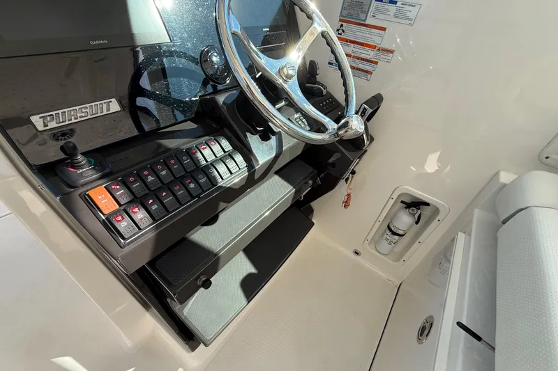 Slide: The Image of 2022 Pursuit DC 326 Dual Console helm with steering wheel and control panel. - 15