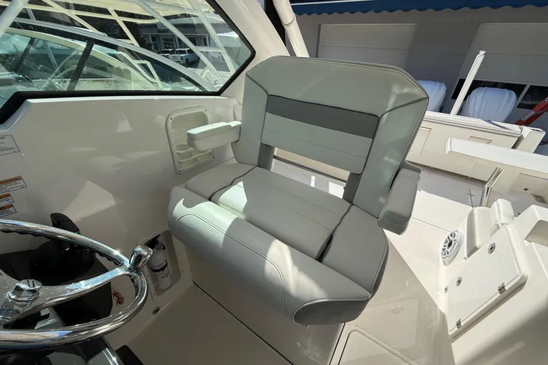 Slide: The Image of Captain's seat on 2022 Pursuit DC 326 Dual Console boat, featuring sleek design and comfortable upholstery. - 16
