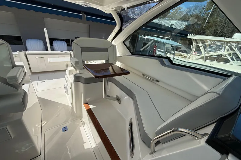 Slide: The Image of 2022 Pursuit DC 326 Dual Console interior with seating and table, showcasing luxury design. - 17