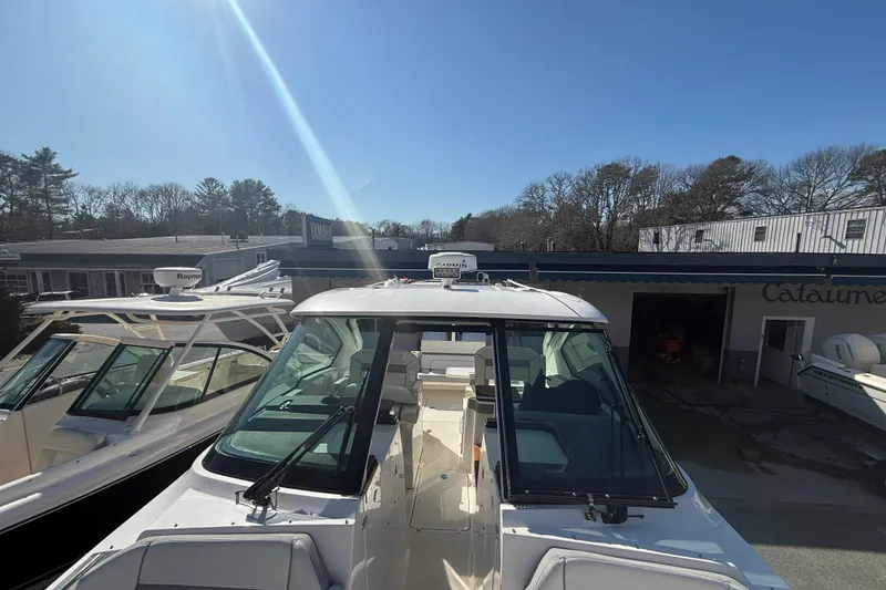 Slide: The Image of 2022 Pursuit DC 326 Dual Console boat displayed outdoors under clear blue sky. - 23