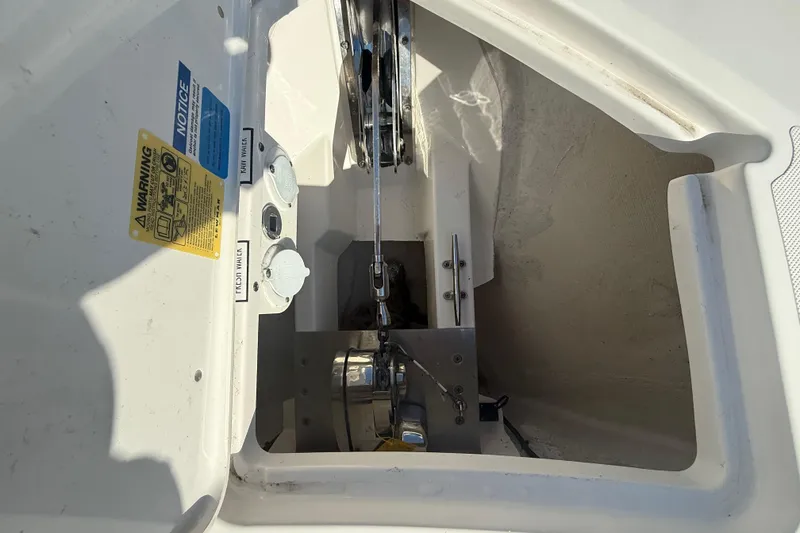 Slide: The Image of Anchor compartment of 2022 Pursuit DC 326 Dual Console boat with warning labels. - 24