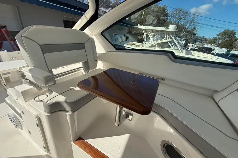 Slide: The Image of Interior of 2022 Pursuit DC 326 Dual Console boat with seating and wooden table. - 32