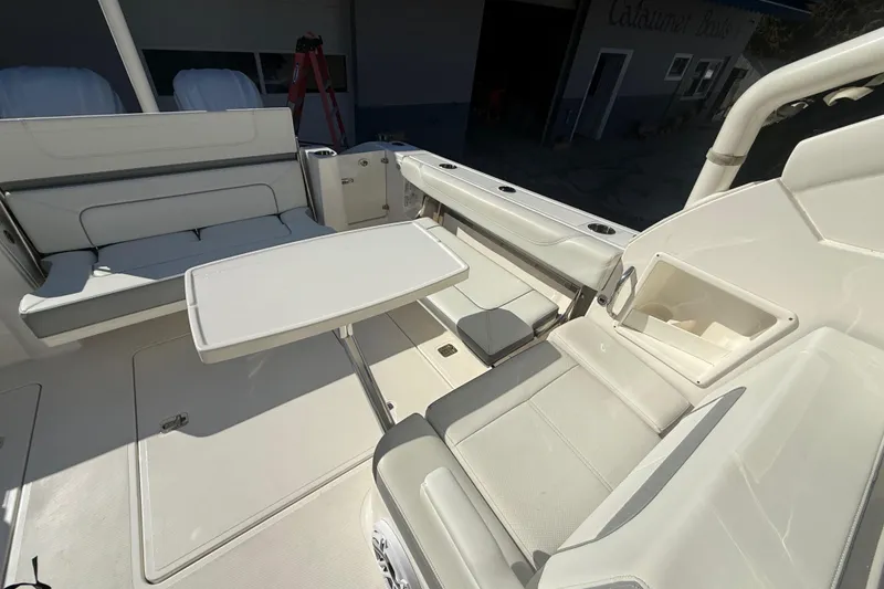Slide: The Image of 2022 Pursuit DC 326 Dual Console boat interior with seating and table setup. - 33