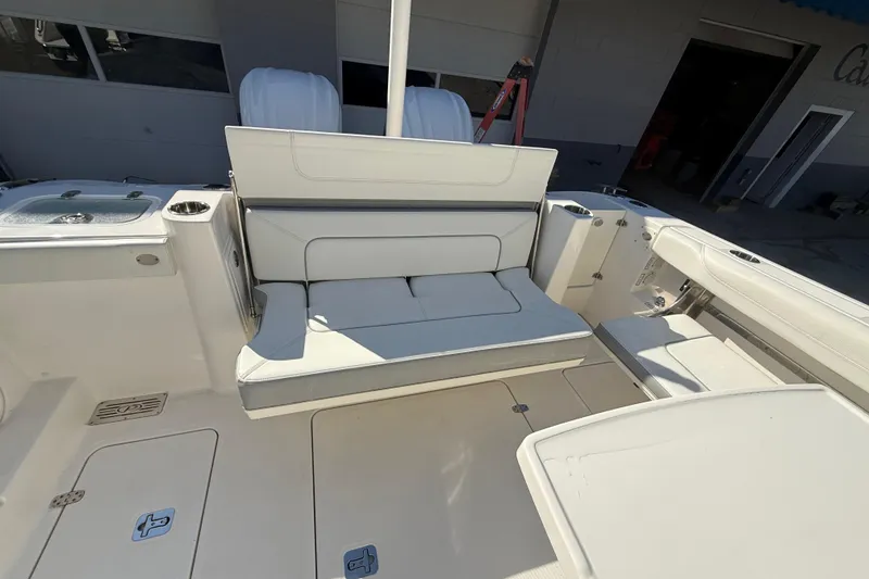 Slide: The Image of 2022 Pursuit DC 326 Dual Console boat interior with white seating and storage compartments. - 34