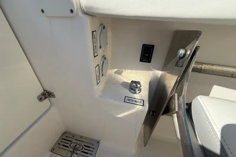 Slide: The Image of 2022 Pursuit DC 326 Dual Console boat interior showing fresh water access and controls. - 36