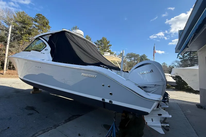 Slide: The Image of 2022 Pursuit DC 326 Dual Console boat with Yamaha engine, parked outdoors under blue sky. - 38