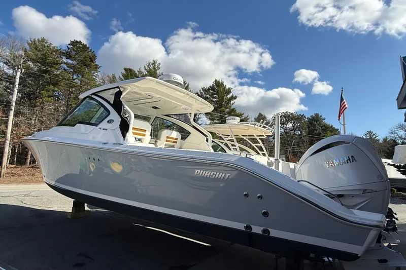 Slide: The Image of 2022 Pursuit DC 326 Dual Console boat with Yamaha engine, parked outdoors under blue sky. - 4