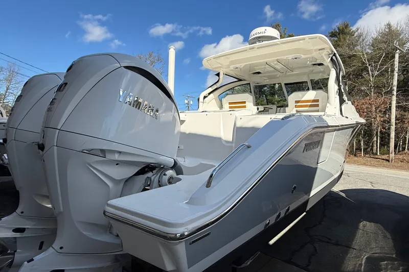 Slide: The Image of 2022 Pursuit DC 326 Dual Console boat with Yamaha engines, parked outdoors under blue sky. - 6