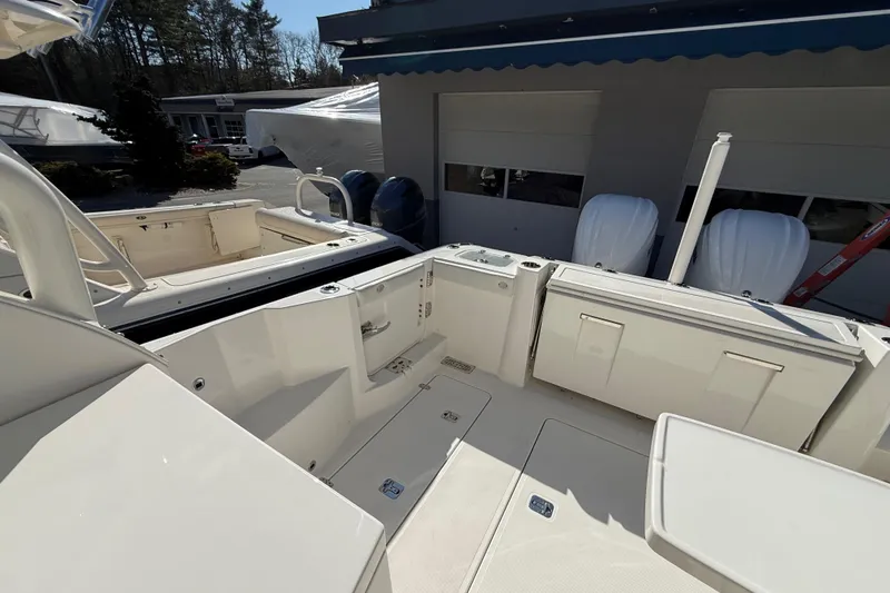 Slide: The Image of 2022 Pursuit DC 326 Dual Console boat interior, showcasing spacious deck and seating area. - 9