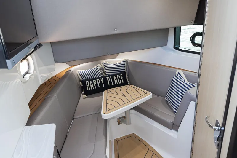Slide: The Image of 2026 Hurricane SunDeck 3200 OB cabin interior with cozy seating and nautical decor. - 13
