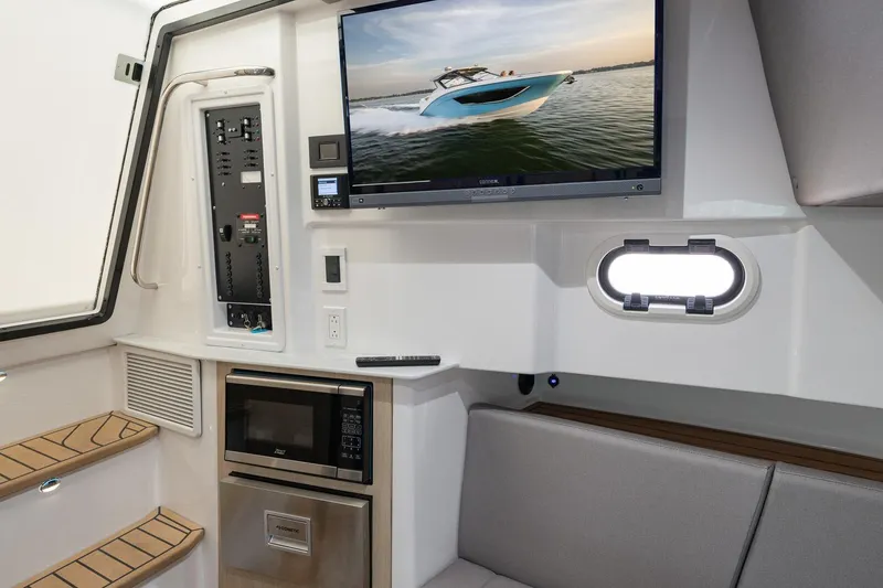 Slide: The Image of Interior of 2026 Hurricane SunDeck 3200 OB with TV, microwave, and seating area. - 14